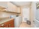 Functional laundry room with a washer, dryer, and overhead cabinets for ample storage and a tile floor at 5115 Sand Trap Ct, Monroe, NC 28112