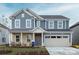 Charming two-story home featuring a combination of stone and siding, a two-car garage, and a covered entryway at 5247 Hatcher Creek Rd # 48, Charlotte, NC 28215