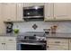 Close-up of modern oven in a kitchen featuring sleek countertops and stylish tile backsplash at 5467 Whiting Ave, Kannapolis, NC 28083