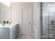 Bathroom with dual sinks, gray cabinetry, and a tiled shower with glass door and gray tile at 6020 Chumbley Point Rd # 73, Charlotte, NC 28215