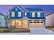 Charming two-story blue home featuring a two-car garage, stone accents, and a well-manicured lawn at 6020 Chumbley Point Rd # 73, Charlotte, NC 28215