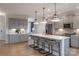 Spacious kitchen features a large island with seating, gray cabinets, stainless steel appliances, and modern lighting at 6020 Chumbley Point Rd # 73, Charlotte, NC 28215