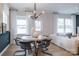 Open living room with dining area, modern lighting, large windows, and stylish furnishings for entertaining at 6020 Chumbley Point Rd # 73, Charlotte, NC 28215