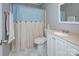 Bathroom featuring tile floors, white vanity and mirror, and shower with patterned blue curtain at 6201 Sellars Ct, Charlotte, NC 28211