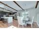 Bright kitchen and dining area featuring dark cabinets, stainless steel appliances, and wood beam accents at 6201 Sellars Ct, Charlotte, NC 28211