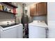 Functional laundry room equipped with modern machines, storage cabinets, and shelving for supplies at 6201 Sellars Ct, Charlotte, NC 28211