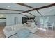 Open-concept living room with exposed beams, a sectional sofa, and seamless flow to the kitchen and dining area at 6201 Sellars Ct, Charlotte, NC 28211