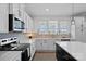 Updated kitchen with sleek appliances, white cabinets, and wood floors at 650 Scotch Meadows Loop, Monroe, NC 28110