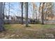 Fenced backyard with mature trees, swing set, and trampoline at 6645 Allness Glen Ln, Charlotte, NC 28269