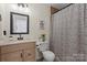 Cozy bathroom with patterned shower curtain, neutral colors, and classic fixtures at 6645 Allness Glen Ln, Charlotte, NC 28269