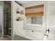Bright bathroom with a tub, walk-in shower, and wooden shelving, offering a relaxing space at 6645 Allness Glen Ln, Charlotte, NC 28269