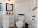 Half bathroom with toilet and vanity, and mirror at 6645 Allness Glen Ln, Charlotte, NC 28269