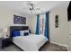 Comfortable bedroom features a ceiling fan, large window with curtains, and a stylish headboard at 6645 Allness Glen Ln, Charlotte, NC 28269
