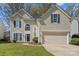 Classic two-story home with well-kept lawn, arched windows, and two-car garage at 6645 Allness Glen Ln, Charlotte, NC 28269