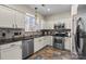 Well-lit kitchen equipped with stainless steel appliances, tile backsplash and stone countertops at 6645 Allness Glen Ln, Charlotte, NC 28269