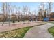 Community playground with swings and slides, surrounded by trees at 6645 Allness Glen Ln, Charlotte, NC 28269