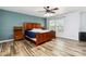 Bright bedroom featuring wood-look floors, a ceiling fan, and a large window for ample natural light at 707 Sinclair Dr, Monroe, NC 28112