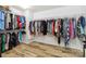 Walk-in closet with hanging clothes and wood flooring at 707 Sinclair Dr, Monroe, NC 28112