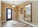 Inviting entryway with wood-look floors, stylish mirror, and decorative wall art, illuminated by a modern light fixture at 707 Sinclair Dr, Monroe, NC 28112