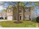 Charming two-story home with brick and vinyl siding, showcasing a well-maintained front yard and mature tree at 707 Sinclair Dr, Monroe, NC 28112
