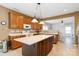 Spacious kitchen featuring an island with breakfast bar, pendant lighting, tile backsplash, and stainless steel appliances at 707 Sinclair Dr, Monroe, NC 28112