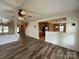 Open-concept living room with ceiling fan, wood floors and access to kitchen at 707 Sinclair Dr, Monroe, NC 28112