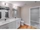Bathroom with double sink vanity, quartz countertops, modern lighting, and walk in closet at 7444 Malabar Rd # 14, Huntersville, NC 28078