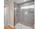 Modern bathroom with grey tile shower, glass door, and wood-look flooring, creating a sleek and inviting space at 7444 Malabar Rd # 14, Huntersville, NC 28078