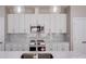 Updated kitchen with white cabinets, marble backsplash, stainless appliances, and large island at 7444 Malabar Rd # 14, Huntersville, NC 28078