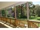 Inviting front porch with wood railing overlooks the lush green yard and trees at 7780 Stokes Ferry Rd, Salisbury, NC 28146