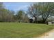 Large yard with a shed, trees, and a patriotic flag, providing a sense of serenity and space at 7780 Stokes Ferry Rd, Salisbury, NC 28146