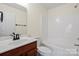 Bathroom features a dark wood vanity, toilet, and shower with tub and white walls at 8453 Big Creek Ct, Charlotte, NC 28105