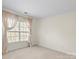 Carpeted bedroom featuring a window with blinds and neutral paint throughout at 8453 Big Creek Ct, Charlotte, NC 28105
