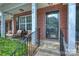 Welcoming brick front porch with seating area, wrought iron railing, and decorative glass front door with address at 8453 Big Creek Ct, Charlotte, NC 28105