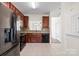 Fully equipped kitchen with stainless steel refrigerator, dark wood cabinets, and tile backsplash at 8453 Big Creek Ct, Charlotte, NC 28105