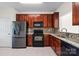 Well-lit kitchen featuring stainless steel appliances, granite countertops and sleek dark wood cabinetry at 8453 Big Creek Ct, Charlotte, NC 28105