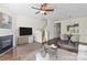 Inviting living room with fireplace, ceiling fan, hardwood floors, and adjacent dining area for seamless entertaining at 8453 Big Creek Ct, Charlotte, NC 28105