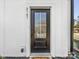 A contemporary front door with glass pane and modern hardware is surrounded by white trim and dark house numbers at 8707 Nolley Ct, Charlotte, NC 28270