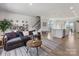 Open-concept living room showing hardwood floors, large sofa, stairs, and kitchen island at 8707 Nolley Ct, Charlotte, NC 28270