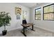 Well-lit office space with neutral carpet, a dark work desk with plants, and a bright window view at 8707 Nolley Ct, Charlotte, NC 28270