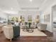 Bright living room featuring hardwood floors, tray ceiling, neutral decor, and abundant natural light at 1026 Mapletree Ln, Indian Trail, NC 28079