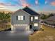 Inviting two-story home featuring a two-car garage and charming balcony under a colorful sunset sky at 10270 Lakeshore Dr, Lancaster, SC 29720