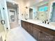 Bright bathroom showcasing double vanity and glass shower, connected to a laundry area at 174 Fulworth Nw Dr # 65, Concord, NC 28027