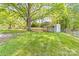 Spacious backyard featuring a storage shed with a covered porch, lush greenery, fencing, and a mature shade tree at 1905 Wood St, Gastonia, NC 28052