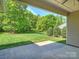 Covered back patio offering an expansive green backyard with lush landscaping and mature trees at 2030 Gloucester St, Weddington, NC 28104