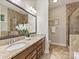 Bathroom features granite countertops, dual sinks, tile floors, and walk-in shower with glass door at 2030 Gloucester St, Weddington, NC 28104