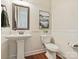 Charming bathroom featuring a pedestal sink, wainscoting, decorative art, and a framed mirror at 2030 Gloucester St, Weddington, NC 28104