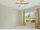 Cozy bedroom featuring a ceiling fan, neutral carpet, and a window offering a pleasant view at 2030 Gloucester St, Weddington, NC 28104