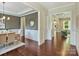 Dining room showcasing hardwood floors, wainscoting, chandelier, and views into other living spaces at 2030 Gloucester St, Weddington, NC 28104