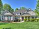 Charming single-story home featuring a manicured lawn, stone accents, and a welcoming covered front porch at 2030 Gloucester St, Weddington, NC 28104